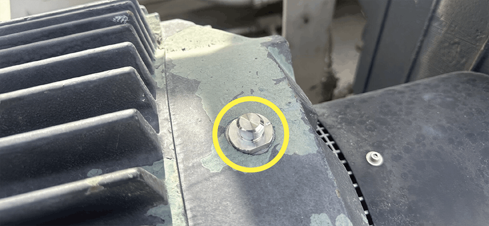 A photo of an MH107-1B Quick Disconnect Stud adhesive-mounted on a motor.