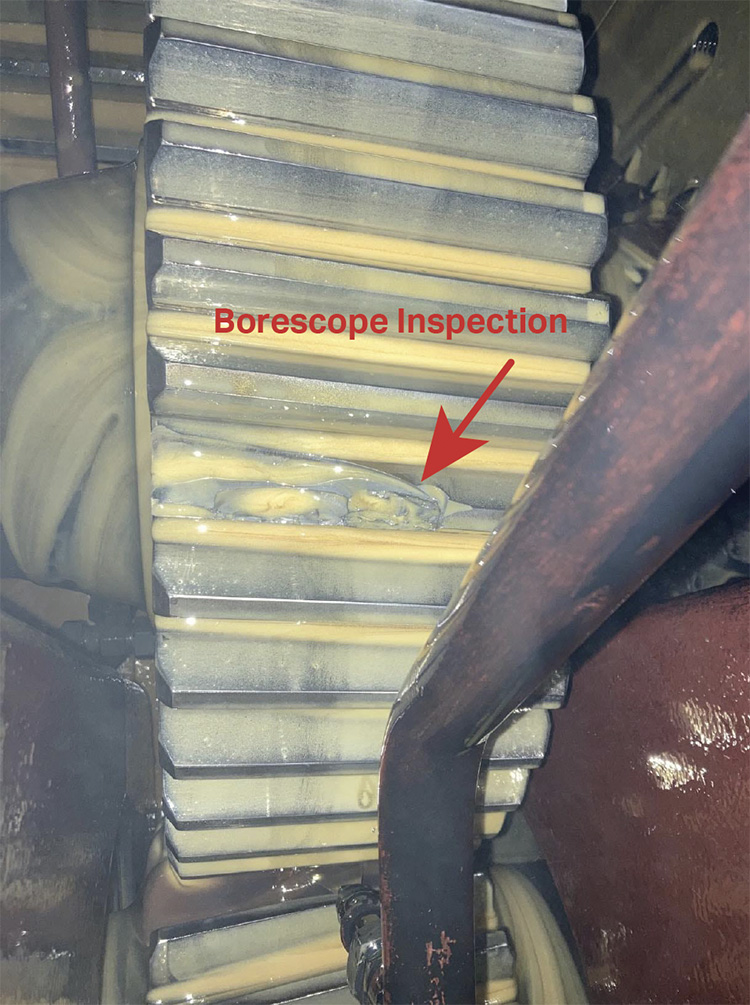 Borescope Inspection text with a red arrow pointing to a section of a broken gear tooth in a gear box