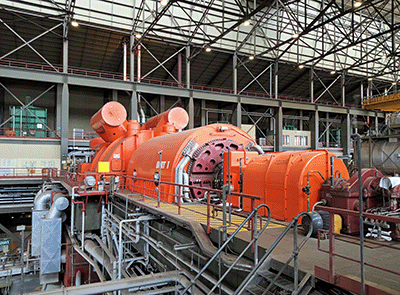 A large industrial gas turbine inside a factory.